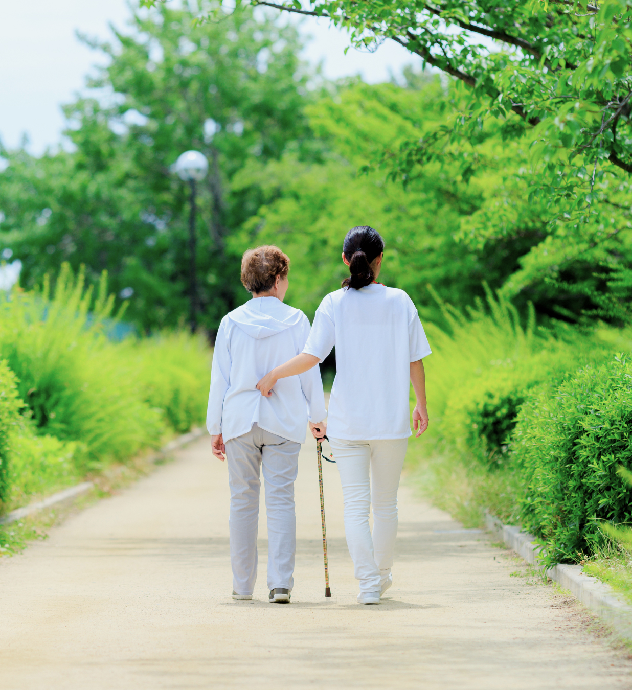 散歩する高齢女性と介護士